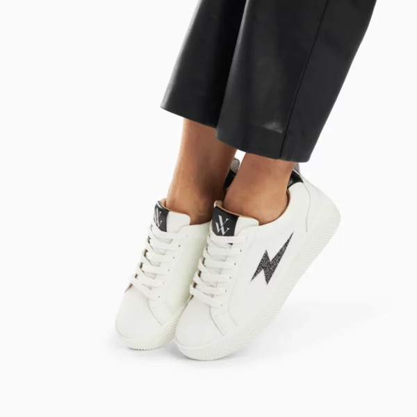 - Baskets en similicuir blanc - Découpe en forme d'éclair en similicuir noir à paillettes argent et anthracite - Patch arrière en similicuir noir texturé - Fermeture à lacets blancs - Bout rond - Semelle épaisse blanche striée Hauteur du talon : 4 cm Hauteur de la plateforme : 2,5 cm Hauteur de la tige : 6 cm Ce modèle taille petit, prenez la taille du dessus.